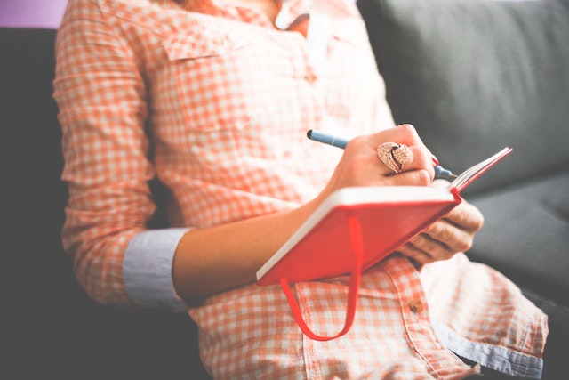 une femme écrit dans son journal